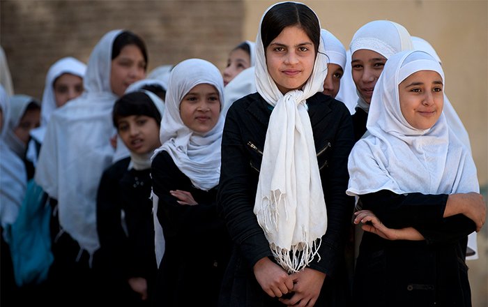 A photo of girls standing patiently in a line at school.