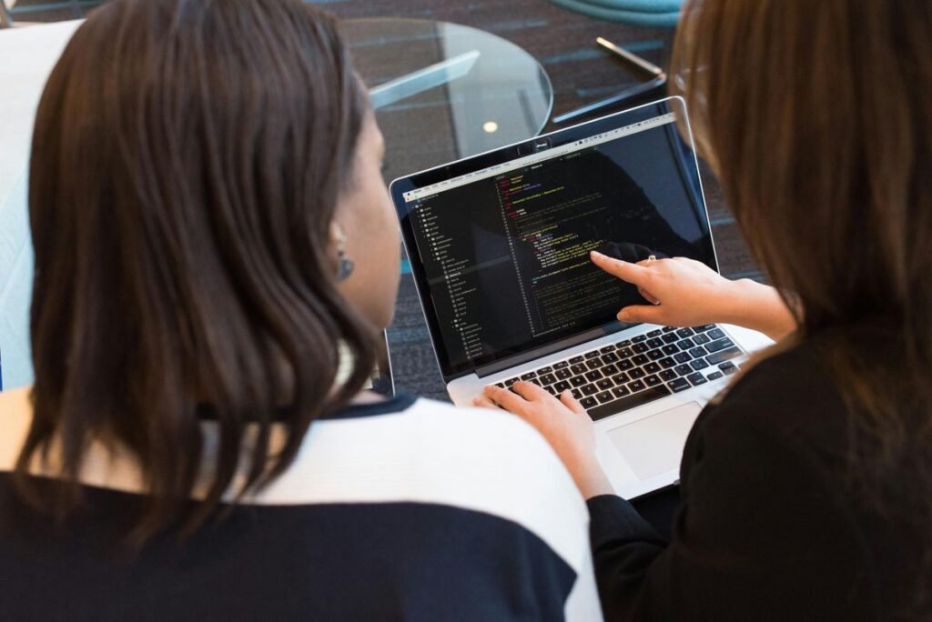 Two women look at data on a computer